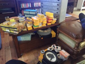 An image of several dozen boxes of photographic slides stacked all over my coffee table
